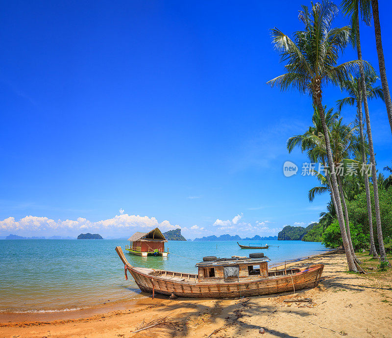 在泰国的kooh Yao Noi海滩上有棕榈树的旧船